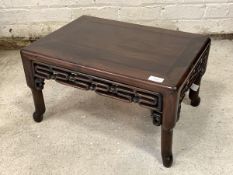 A 20th century Chinese hardwood low table, with pierce carved frieze, raised on turned supports