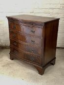 A Georgian style mahogany serpentine chest, with brushing slide over four drawers, raised on bracket