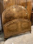 A Queen Anne style figured walnut 4'6" double bed, the arched and panelled headboard with conforming