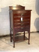 An Edwardian mahogany sheet music cabinet, the raised back over five fall front drawers, raised on