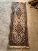 A Persian Tabriz design runner rug, with double medallion on ivory field, enclosed by a guarded