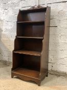 A Georgian style mahogany floor standing waterfall bookcase, fitted with four open shelves, raised