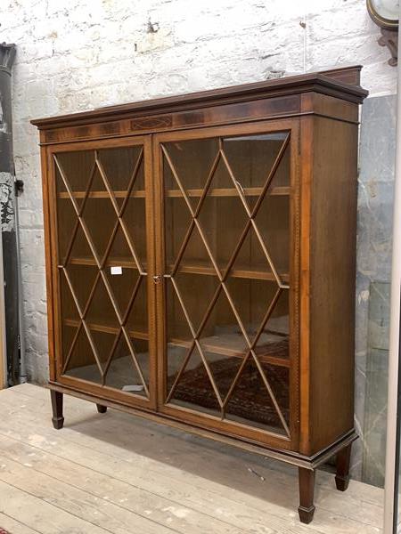 A Sheraton revival inlaid mahogany bookcase, early 20th century, with raised back over two