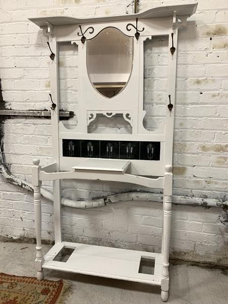 A white painted Art Nouveau style hall stand, with bevelled mirror, six coat hooks, inset tiles,