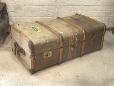 An early 20th century steamer trunk, wooden bound with leather carry handle to each end, the