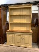 A Traditional cream painted dresser, the two height plate rack over base fitted with three cupboards