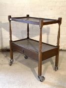 A stained oak and beech two tier drinks trolley, circa 1940's, fitted with drawer and raised on