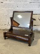 A Victorian mahogany toilet mirror, the rectangular mirror swivelling between two scrolled uprights,