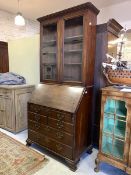 An 18th century walnut and mahogany bureau bookcase, the associated top with two glazed doors