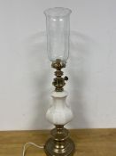 A table lamp, possibly converted from oil burning lamp, the glass shade above a ceramic body on