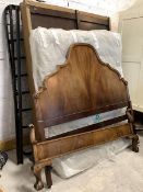 A 20th century mahogany 5' double bed, the arched headboard on castors and scrolled footboard on