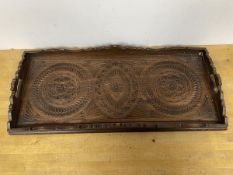 A modern Indian drinks tray, the top with carved decoration beneath a raised moulded edge, with