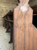 A large Victorian stained pine pew, with panelled back and seat, raised on shaped panel end supports