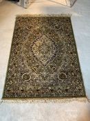 A Persian Kashan design ground rug of ivory, blue, green and red, with floral medallion and
