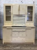 A Vintage cream painted kitchen larder unit, the top centred with a double cupboard over a tambour