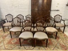 A set of twelve (10+2) Hepplewhite style mahogany dining chairs, the shield backs with wheat sheaf