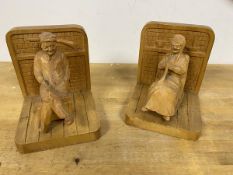 A pair of hand carved bookends, the upright in the form of a hearth with a seated figure to each,