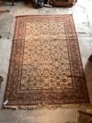A Persian design carpet, the ivory field with interlaced trailing foliate enclosed by a red