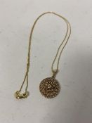 A 9ct gold circular pendant with radiating design set diamonds, on a 14ct gold trace link chain (