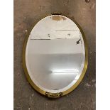 A modern oval wall mirror with bevelled edge within a gilt frame (70cm x 46cm)