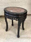 An early 20th century Chinese hardwood jardiniere stand of oval outline, the top with inset marble
