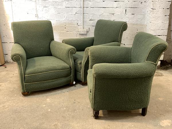 A pair of Art Deco period green upholstered armchairs, raised on compressed bun supports with