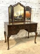 A 20th century mahogany knee hole dressing table, the associated triptych mirror in conforming frame