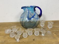 A glass water pitcher of squat form (20cm), a group of thistle style whisky measures (a lot)