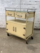 A vintage chrome and cream painted tubular hospital trolley, with plate glass top over two