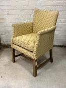 A mid 20th century upholstered easy chair, with squab cushion, raised on square section supports
