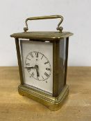 An early to mid 20thc carriage clock with three glass sides, the paper dial with roman numerals,