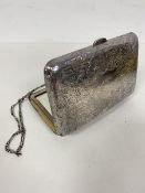 A late 19thc lady's silver evening bag, the exterior with scrolling vines, interior with mirror,