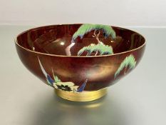 A 1930's Carlton Ware "Oxford" bowl, boldly painted with flowers and trees against a rouge royale
