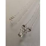 A diamond pendant necklace, the bow motif suspending a pear-shaped drop pave set with round