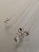 A diamond pendant necklace, the bow motif suspending a pear-shaped drop pave set with round