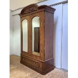 A Victorian figured walnut double wardrobe, the arched top over a frieze with applied scrolling
