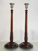 A pair of George III style white metal mounted turned mahogany candlesticks, each with domed