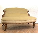 A late Victorian walnut-framed boudoir settee, the back with acanthus-carved "S" scroll terminals,