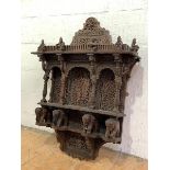 An Anglo-Indian open wall shelf, early 20th century, profusely carved with figures and pierced