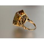 A single stone citrine ring, the large emerald-cut stone four-claw set on split shoulders and a