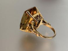 A single stone citrine ring, the large emerald-cut stone four-claw set on split shoulders and a