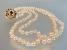 A twin strand cultured pearl necklace on a ruby and seed pearl clasp, the uniform creamy-white