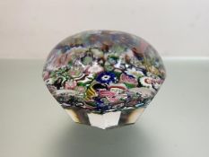 A closely-packed millefiori faceted paperweight, with eight printies. Diameter 7.5cm