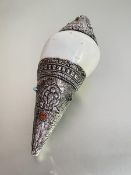 An Indian white metal mounted conch shell, repousse with foliate and geometric decoration and