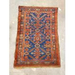 An antique hand-knotted rug, probably Kurdistan, the deep blue field of geometric design, framed