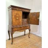 A walnut cabinet on stand, early 18th century and later, the projecting moulded cornice over a