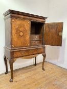 A walnut cabinet on stand, early 18th century and later, the projecting moulded cornice over a