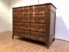 A Continental oak commode, late 19th century, of serpentine outline, the moulded top over four