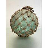 A very large green glass nautical float or bouy, in a rope net. Diameter c. 35cm