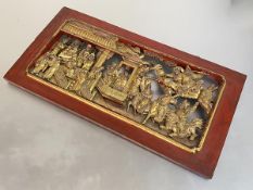 A Chinese carved giltwood panel, elaborately pierced and modelled with deities, musicians and